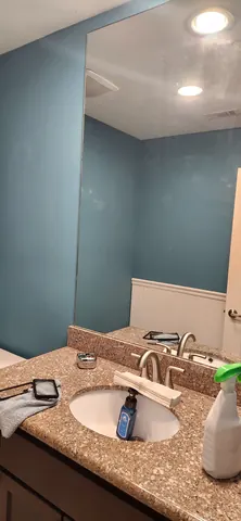Outdated bathroom vanity and light fixture prior to repair
